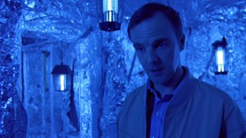 Movie still from “Bug” (2006), directed by William Friedkin – A man standing in front of a wall with lights on it; Medium shot, Low angle