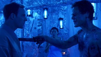 Movie still from “Bug” (2006), directed by William Friedkin – Two people in a room with a woman in the background; Medium shot, Over the shoulder angle