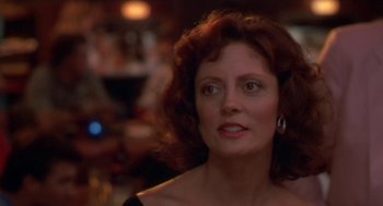 Movie still from “Bull Durham” (1988), directed by Ron Shelton – An older woman with red curly hair looking at the camera; Close Up shot, Over the shoulder angle