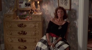 Movie still from “Bull Durham” (1988), directed by Ron Shelton – A woman sitting on a chair in front of a dresser; Medium shot, Over the shoulder angle