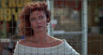 Movie still from “Bull Durham” (1988), directed by Ron Shelton – A woman standing in front of a metal fence; Close Up shot, Over the shoulder angle