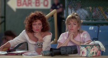 Movie still from “Bull Durham” (1988), directed by Ron Shelton – Two women sitting at a table in front of a fire hydrant; Medium shot, Low angle
