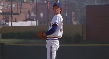 Movie still from “Bull Durham” (1988), directed by Ron Shelton – A baseball player is getting ready to throw the ball; Wide shot, Low angle