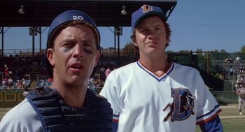 Movie still from “Bull Durham” (1988), directed by Ron Shelton – Two baseball players standing next to each other at a game; Medium shot, Over the shoulder angle