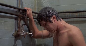 Movie still from “Bull Durham” (1988), directed by Ron Shelton – A man is taking a shower in a bathroom; Close Up shot, High angle