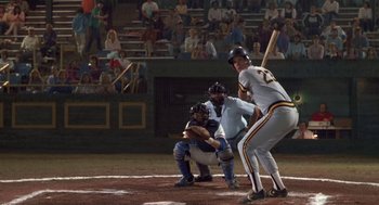 Movie still from “Bull Durham” (1988), directed by Ron Shelton – A baseball player holding a baseball bat on a field; Wide shot, High angle