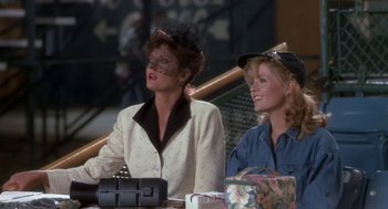 Movie still from “Bull Durham” (1988), directed by Ron Shelton – A couple of women sitting next to each other at a table; Medium shot, Over the shoulder angle