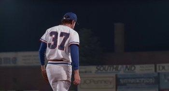 Movie still from “Bull Durham” (1988), directed by Ron Shelton – A baseball player walking on a field at night; Medium shot, Low angle