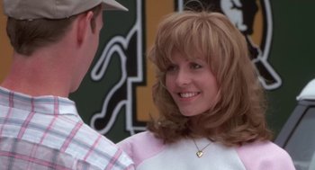 Movie still from “Bull Durham” (1988), directed by Ron Shelton – A young woman smiles while standing next to a young man; Close Up shot, Over the shoulder angle