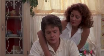 Movie still from “Bull Durham” (1988), directed by Ron Shelton – A man and a woman sitting next to each other in front of a window; Close Up shot, Over the shoulder angle