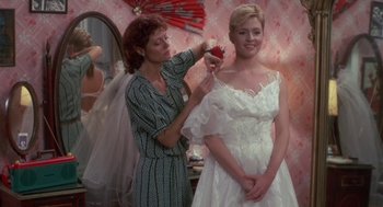 Movie still from “Bull Durham” (1988), directed by Ron Shelton – A woman is helping another woman put on a wedding dress; Medium shot, Over the shoulder angle