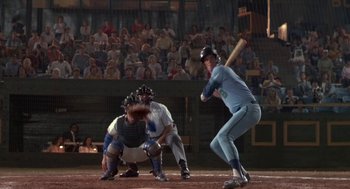 Movie still from “Bull Durham” (1988), directed by Ron Shelton – A baseball player swinging a baseball bat at a game; Wide shot, Overhead angle