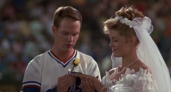 Movie still from “Bull Durham” (1988), directed by Ron Shelton – A man and a woman are holding a yellow rose; Close Up shot, Over the shoulder angle