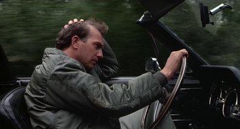 Movie still from “Bull Durham” (1988), directed by Ron Shelton – A man sitting in the driver's seat of a car; Close Up shot, High angle