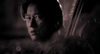 Movie still from “Bullet to the Head” (2012), directed by Walter Hill – A black and white photo of a man's face; Close Up shot, Over the shoulder angle