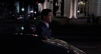 A man wearing a suit and tie sitting in a car
