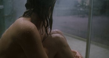 Movie still from “Bullet to the Head” (2012), directed by Walter Hill – A woman sitting on the ground in the rain; Extreme Close Up shot, High angle
