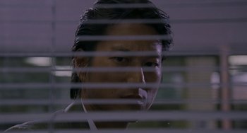 Movie still from “Bullet to the Head” (2012), directed by Walter Hill – A man looking out a window through blinds at night; Close Up shot, Low angle