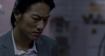 Movie still from “Bullet to the Head” (2012), directed by Walter Hill – A person wearing a suit and tie; Close Up shot, Over the shoulder angle