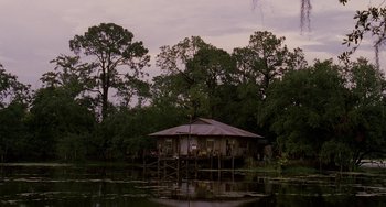 Movie still from “Bullet to the Head” (2012), directed by Walter Hill – A house on stilts in the middle of a body of water; Extreme Wide shot, Low angle