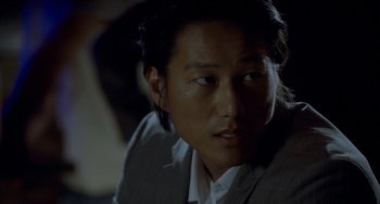 Movie still from “Bullet to the Head” (2012), directed by Walter Hill – A person wearing a suit and tie; Close Up shot, Over the shoulder angle