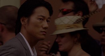 Movie still from “Bullet to the Head” (2012), directed by Walter Hill – A person wearing a hat and a suit; Close Up shot, Over the shoulder angle