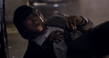 Movie still from “Bullet to the Head” (2012), directed by Walter Hill – A man in a suit and tie holding a gun in his hand; Close Up shot, Over the shoulder angle