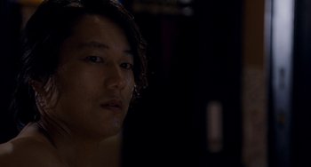 Movie still from “Bullet to the Head” (2012), directed by Walter Hill – A young man is looking into the camera; Close Up shot, Over the shoulder angle