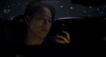 Movie still from “Bullet to the Head” (2012), directed by Walter Hill – A man looking at his cell phone in the back of a car; Close Up shot, Low angle