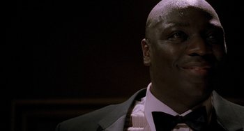 Movie still from “Bullet to the Head” (2012), directed by Walter Hill – A person wearing a suit and bow tie; Close Up shot, Low angle