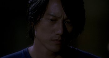 Movie still from “Bullet to the Head” (2012), directed by Walter Hill – A person with long black hair; Close Up shot, High angle