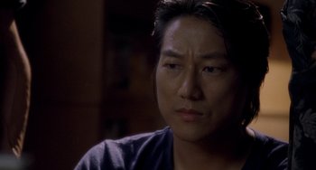 Movie still from “Bullet to the Head” (2012), directed by Walter Hill – A person sitting down looking at the camera; Close Up shot, Over the shoulder angle