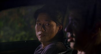 Movie still from “Bullet to the Head” (2012), directed by Walter Hill – A person sitting in a car at night; Close Up shot, Over the shoulder angle