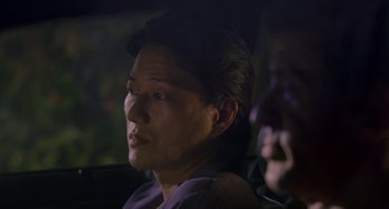 Movie still from “Bullet to the Head” (2012), directed by Walter Hill – A man sitting in a car looking at the camera; Close Up shot, Over the shoulder angle