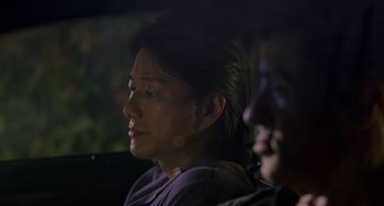 Movie still from “Bullet to the Head” (2012), directed by Walter Hill – A man sitting next to another man in a car; Close Up shot, Over the shoulder angle