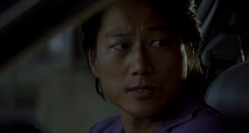 Movie still from “Bullet to the Head” (2012), directed by Walter Hill – A person wearing a purple shirt; Close Up shot, Over the shoulder angle