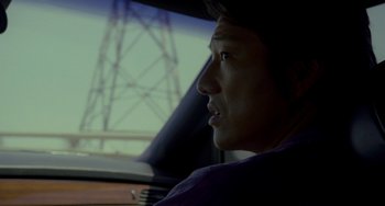 Movie still from “Bullet to the Head” (2012), directed by Walter Hill – A man sitting in the driver's seat of a car; Close Up shot, Over the shoulder angle