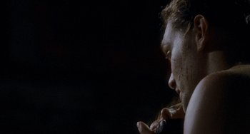 A man is brushing his teeth in the dark