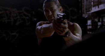 Movie still from “Bullet to the Head” (2012), directed by Walter Hill – A man holding a gun while wearing a black shirt; Close Up shot, Low angle