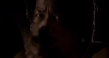 Movie still from “Bullet to the Head” (2012), directed by Walter Hill – A person with a gun in a dark room; Extreme Close Up shot, Low angle