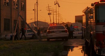 Movie still from “Bullet to the Head” (2012), directed by Walter Hill – A police car parked on the side of the road; Extreme Wide shot, Low angle