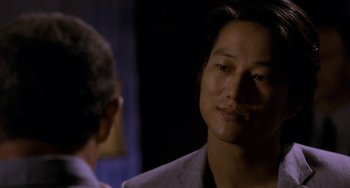 Movie still from “Bullet to the Head” (2012), directed by Walter Hill – A person wearing a suit and tie; Close Up shot, Over the shoulder angle