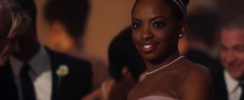 A woman in a white dress with a pearl necklace