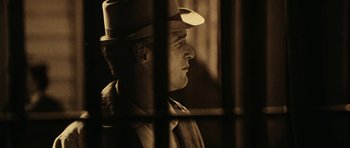 Movie still from “Butch Cassidy and the Sundance Kid” (1969), directed by George Roy Hill – A man wearing a top hat looking out of a window; Close Up shot, Over the shoulder angle