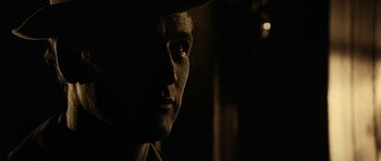 Movie still from “Butch Cassidy and the Sundance Kid” (1969), directed by George Roy Hill – A man's face in a dark room; Close Up shot, Over the shoulder angle