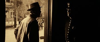 Movie still from “Butch Cassidy and the Sundance Kid” (1969), directed by George Roy Hill – A black and white photo of a man in a hat looking in the mirror; Medium shot, Over the shoulder angle