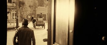 Movie still from “Butch Cassidy and the Sundance Kid” (1969), directed by George Roy Hill – An old photo of a horse drawn carriage in the street; Wide shot, Over the shoulder angle