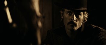 Movie still from “Butch Cassidy and the Sundance Kid” (1969), directed by George Roy Hill – A man in a cowboy hat is smoking a cigarette; Close Up shot, Over the shoulder angle