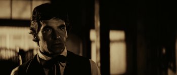 Movie still from “Butch Cassidy and the Sundance Kid” (1969), directed by George Roy Hill – A man wearing a vest and tie in a dark room; Close Up shot, Low angle