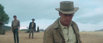 Movie still from “Butch Cassidy and the Sundance Kid” (1969), directed by George Roy Hill – A man in a hat and a jacket standing in the sand; Close Up shot, Over the shoulder angle